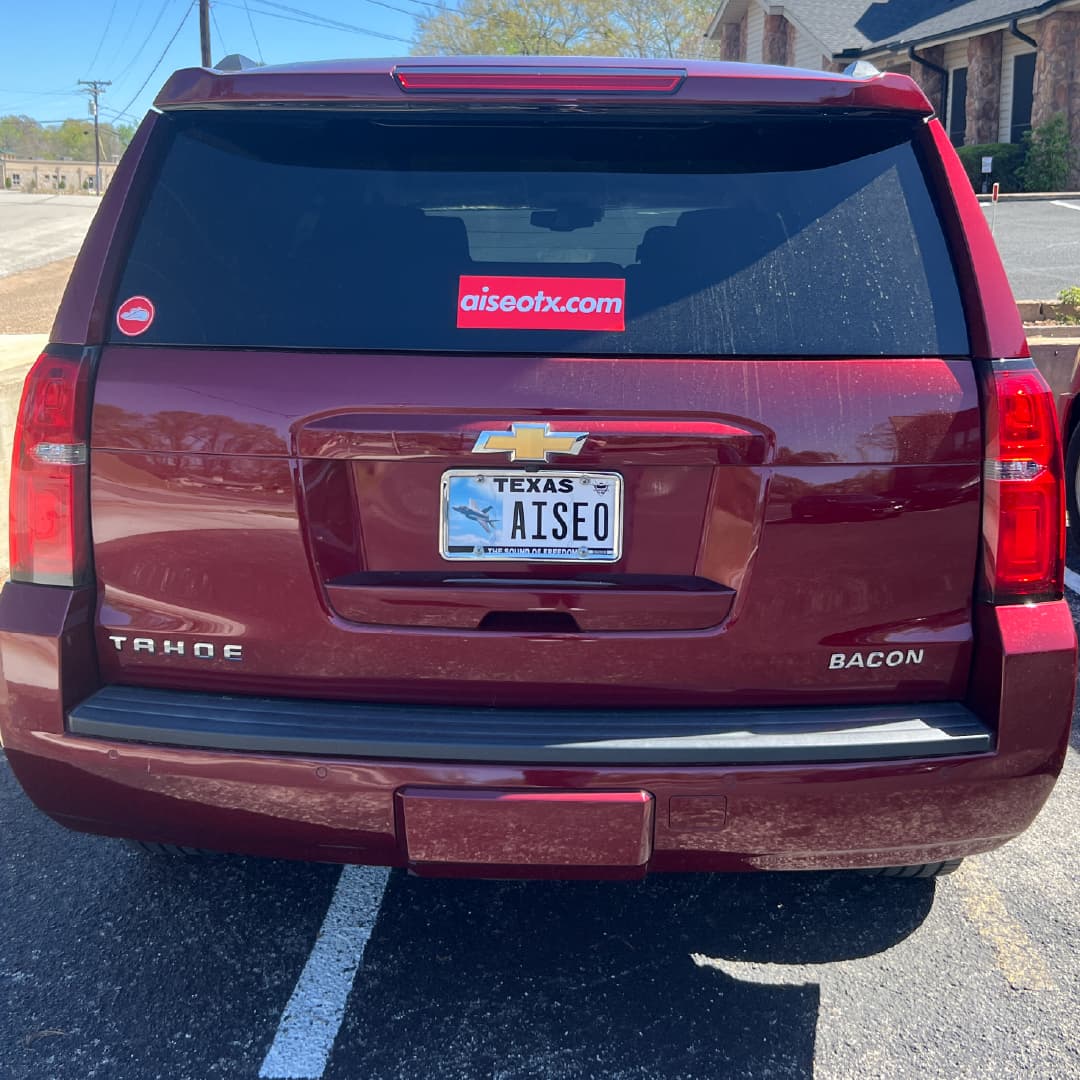 Maroon vehicle in Tyler Texas with AISEO vanity plate and AISEOTX.com sticker on rear window