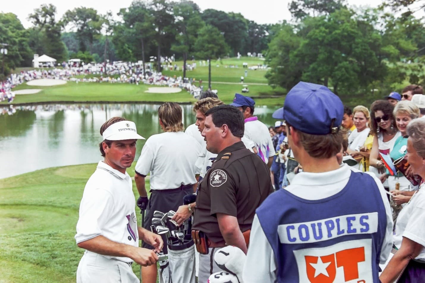 Fred Couples walking off the 15th green at Willow Brook Country Club during the Eisenhower International Golf Classic in Tyler, Texas, surrounded by marshals and spectators.