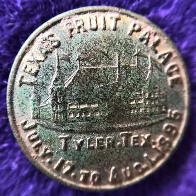 Round 1895 souvenir token with green patina showing the Texas Fruit Palace building, lettered Texas Fruit Palace, Tyler, Tex., July 17 to Aug. 1, 1895